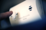 How do home alarm systems defend against environmental threats like floods or carbon monoxide leaks?
